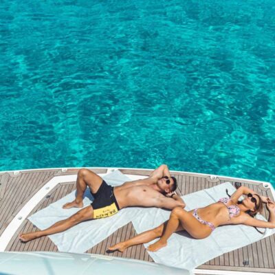 pareja tomando sol plataforma bano yate